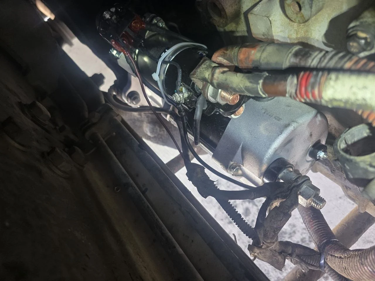 Close-up of a semi truck's failed starter motor during roadside diagnosis