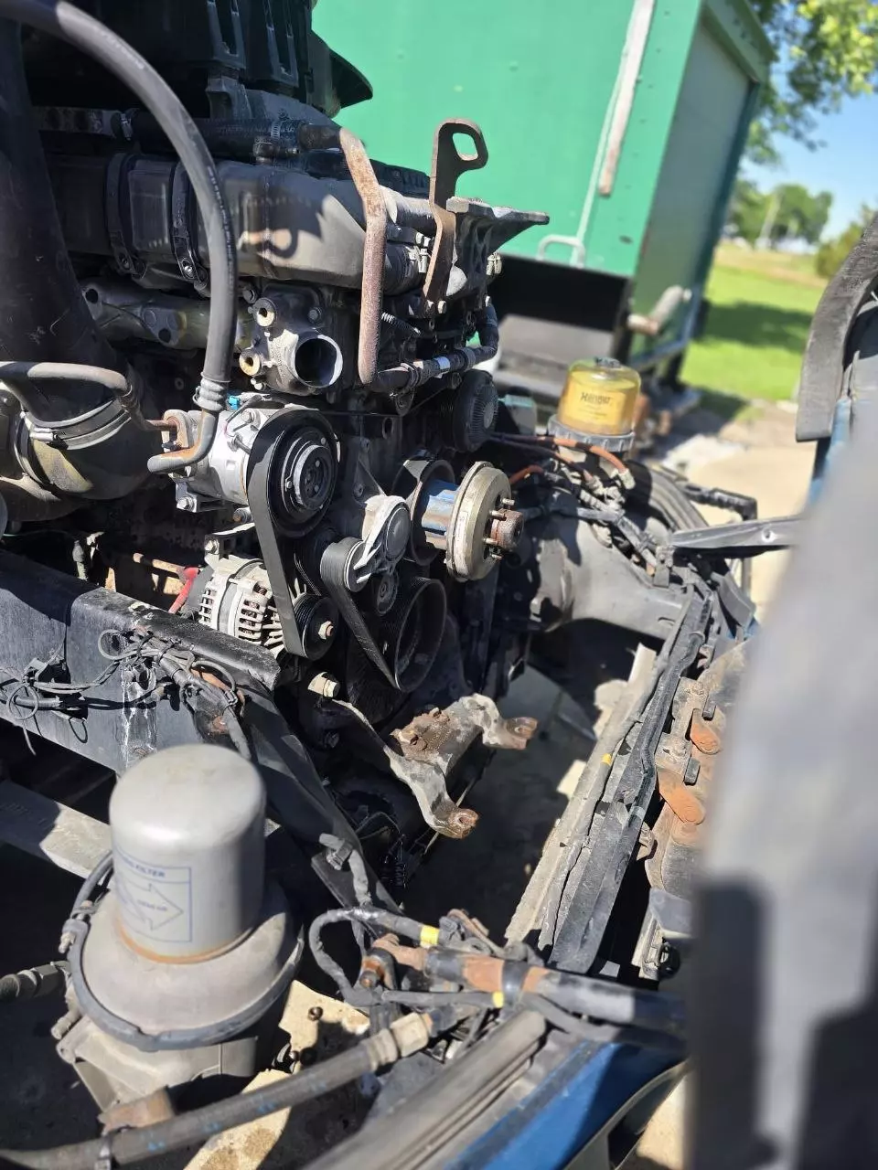 Mechanic inspecting a semi truck engine bay for a coolant leak