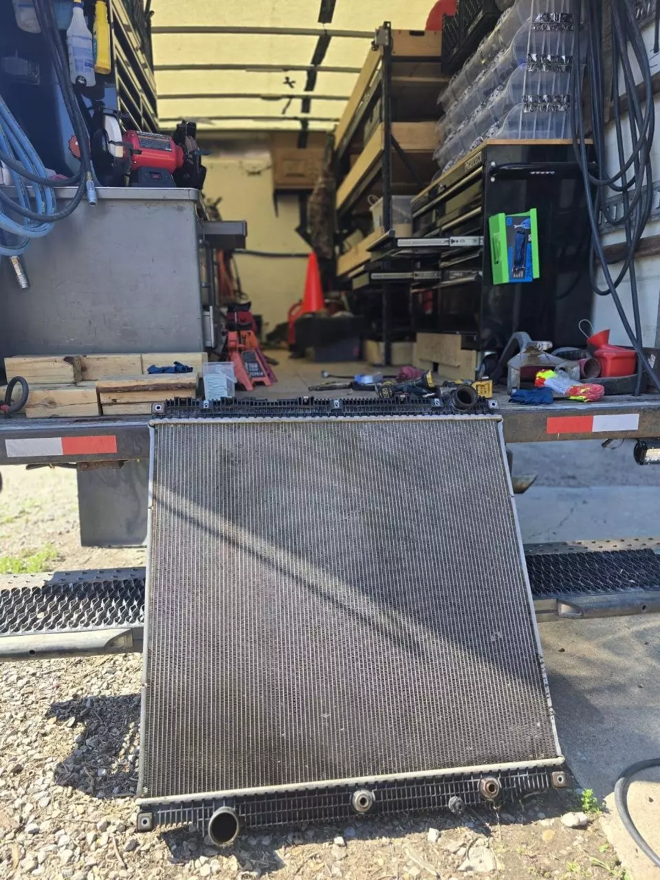 Damaged radiator removed from the truck and set on the service truck tailgate
