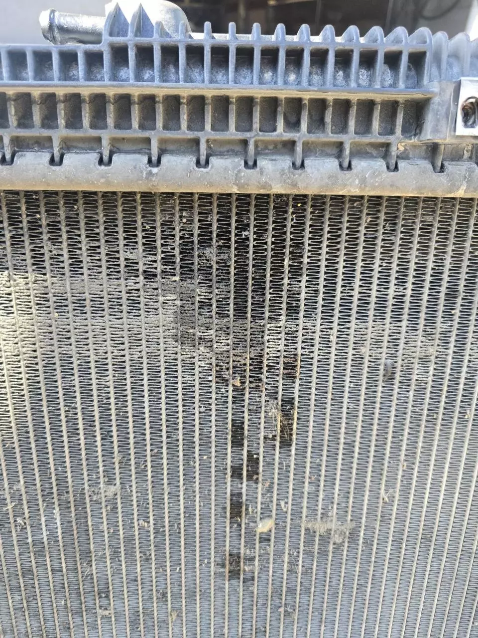 Close-up of radiator core showing multiple leak points