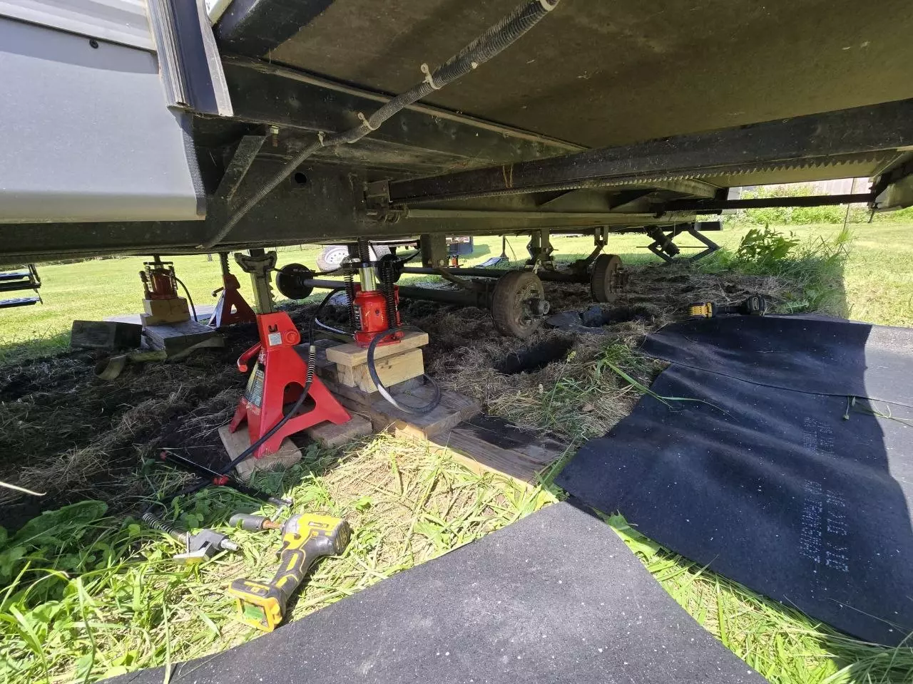 Camper trailer axles and wheels exposed during service